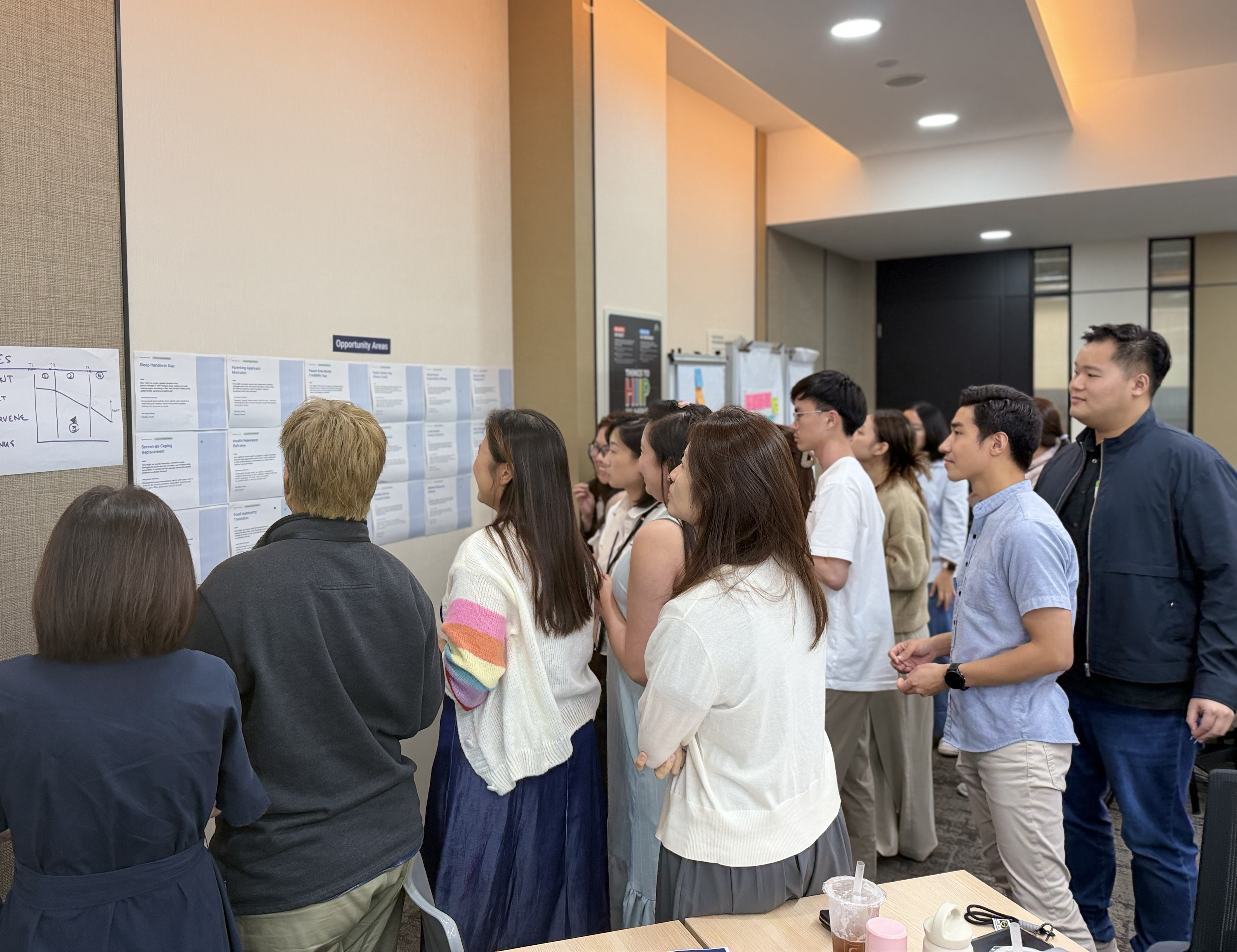 Youth participants during gallery walk — reviewing research findings pinned to wall