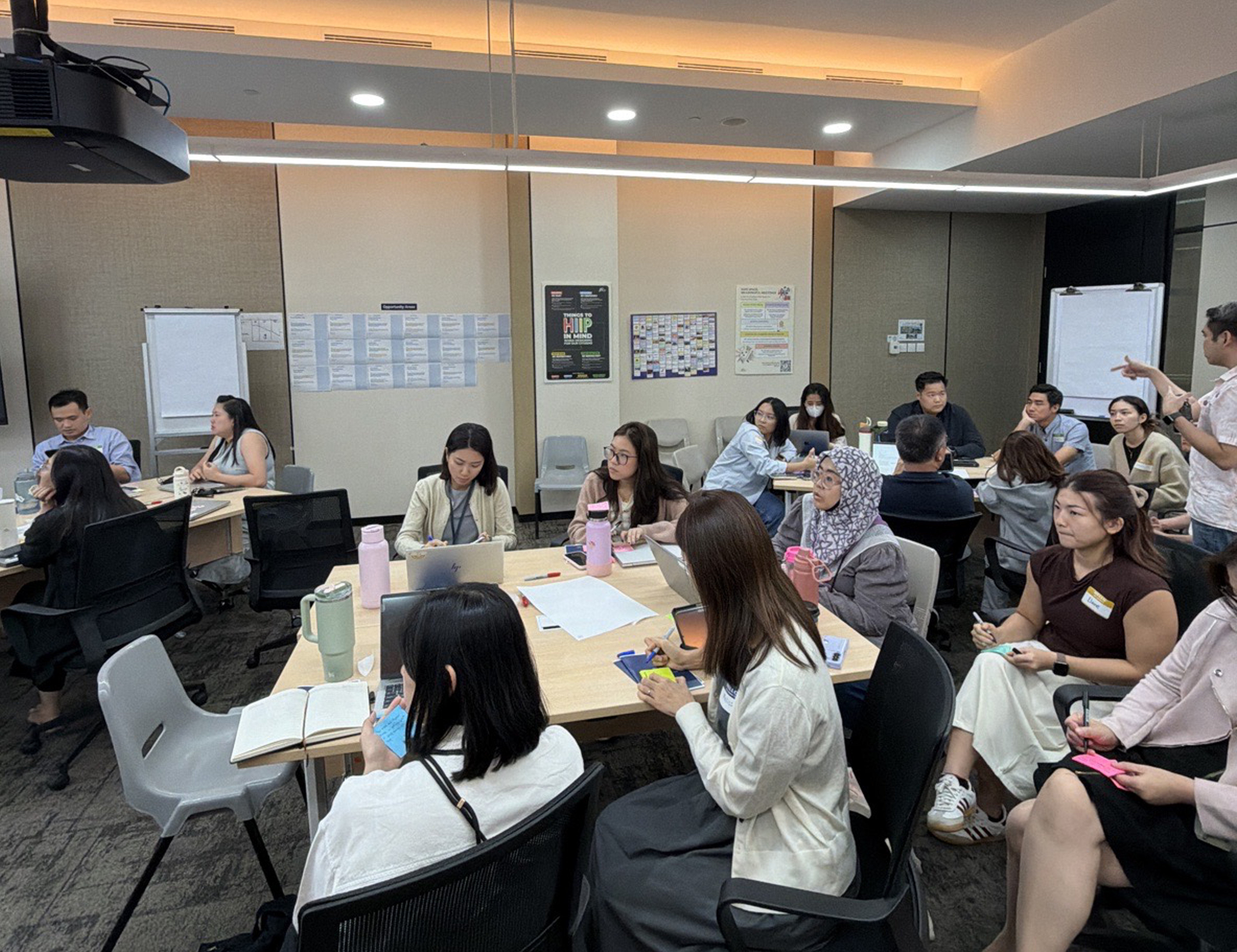 Workshop groups seated at tables during the define phase working session